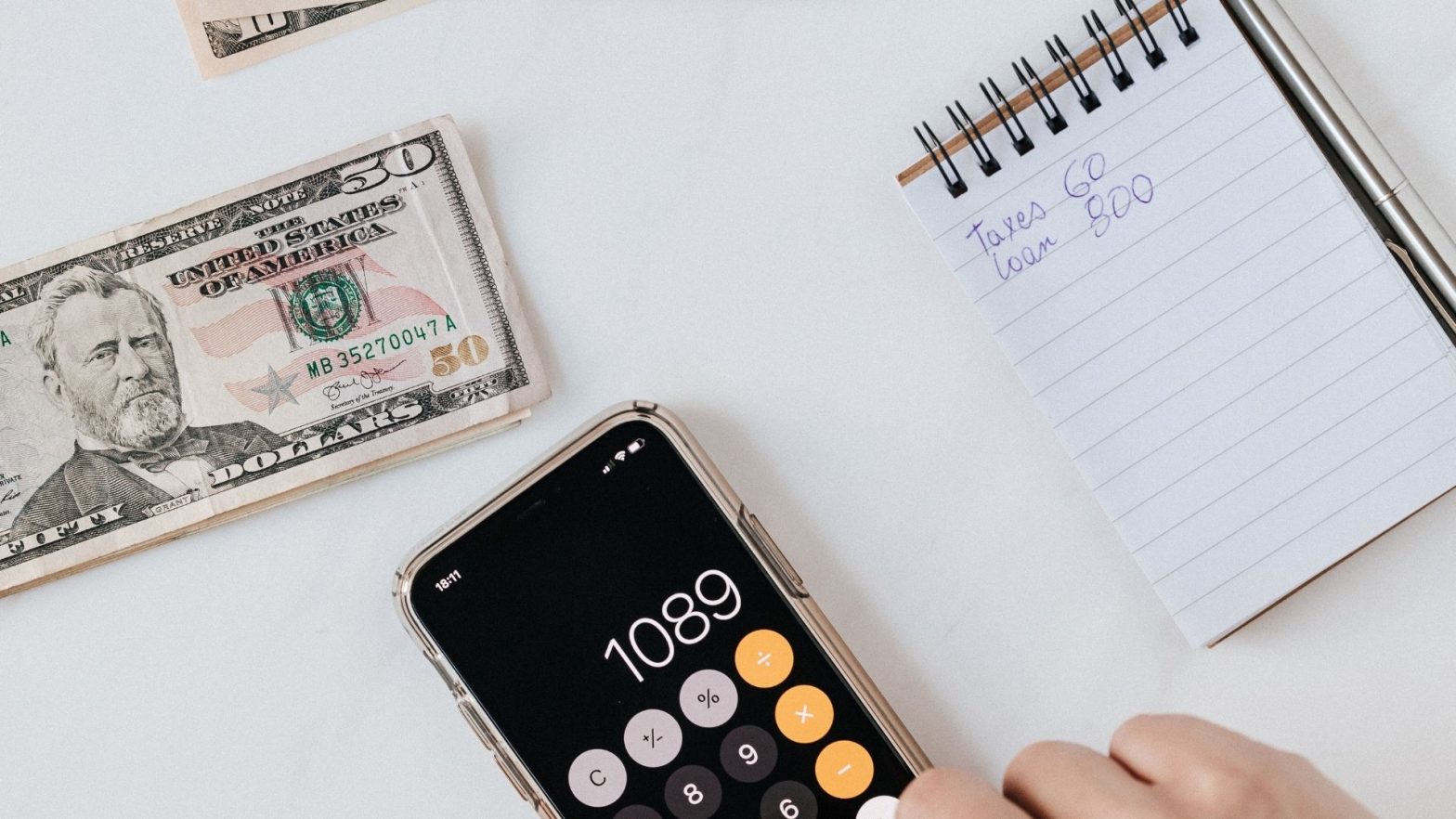 A calculator by cash while someone attempts to handle their taxes at home